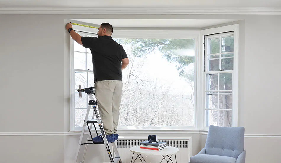 Measure Window Frame for Curtain Installation REGAL Curtains REGAL Curtains A man measuring a window frame before curtain installation, demonstrating how to hang curtains accurately according to proper curtain height rules.